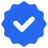 Badge bleu à bord ondulé avec coche blanche au centre, symbole de vérification