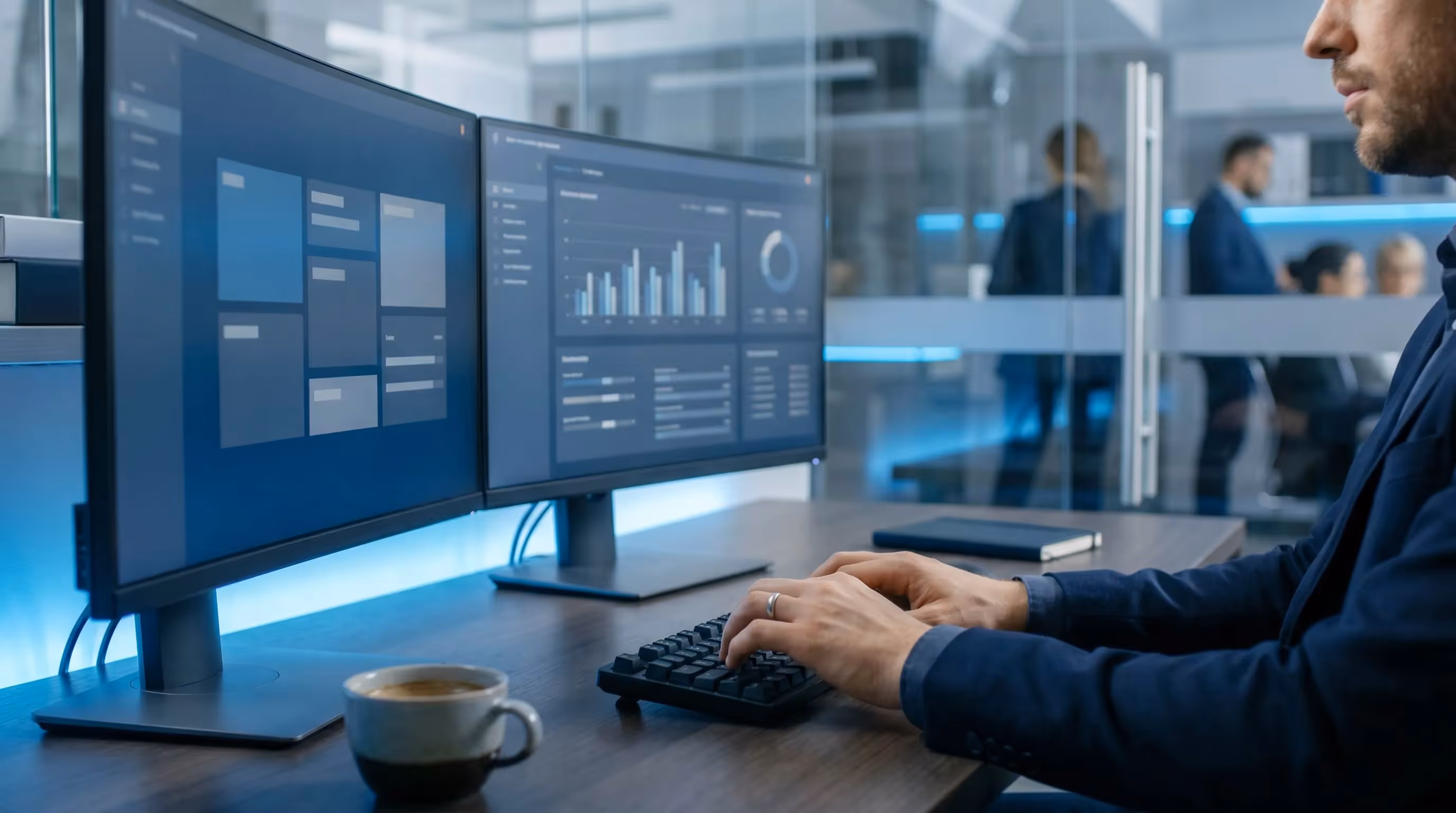 Hands typing an SEO email newsletter on a black keyboard with dual monitors in a dark navy office
