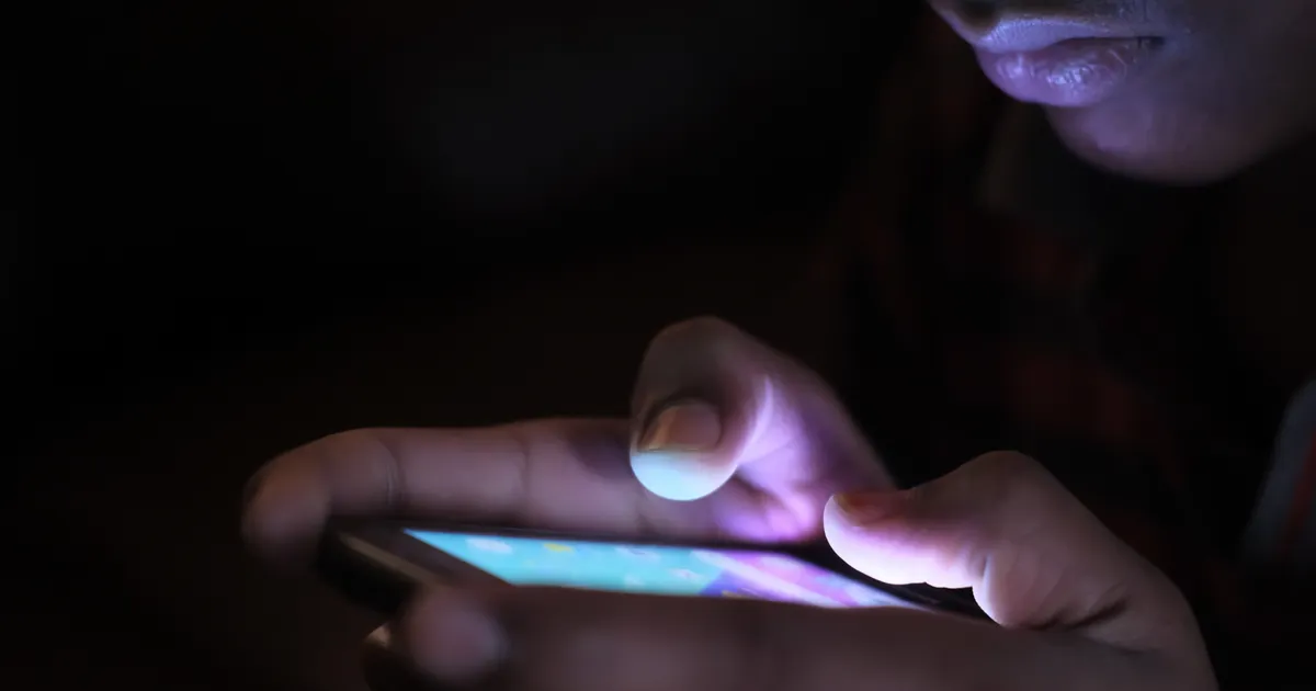 Eine Hand hält ein Smartphone mit einem mobilen Browser, der auf der Adressleiste geöffnet ist