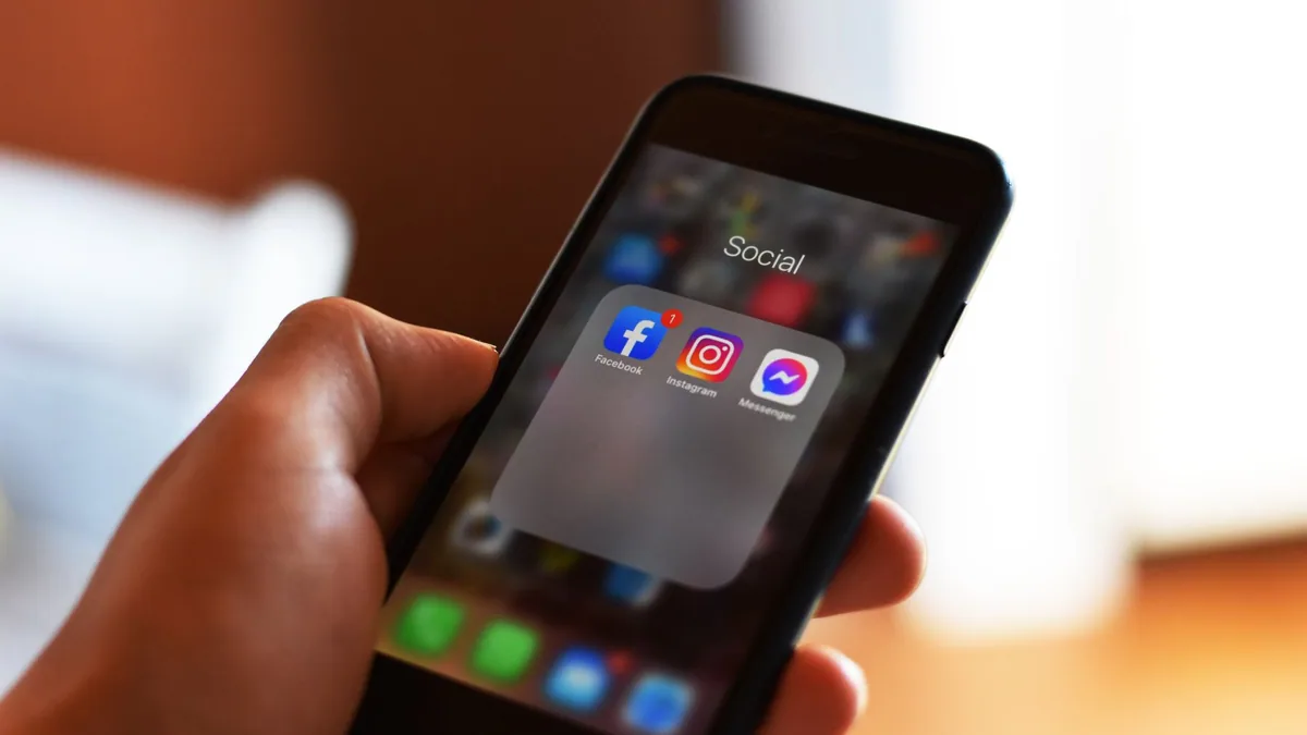 Hand holding a smartphone showing an app store screen, illustrating the ranking of the best app marketing agencies in France