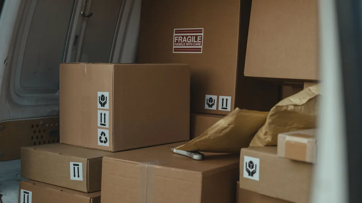 Cardboard parcels stacked in a delivery van, illustrating the ranking of the best Amazon agencies in France