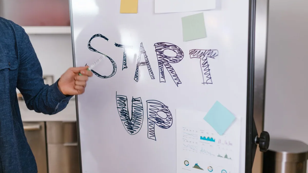 Person presenting a plan on a whiteboard to a startup team, illustrating the ranking of the best growth marketing agencies in France