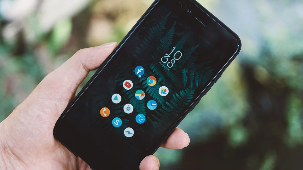 Hand holding a smartphone showing social media apps, illustrating the ranking of the best social media agencies in France