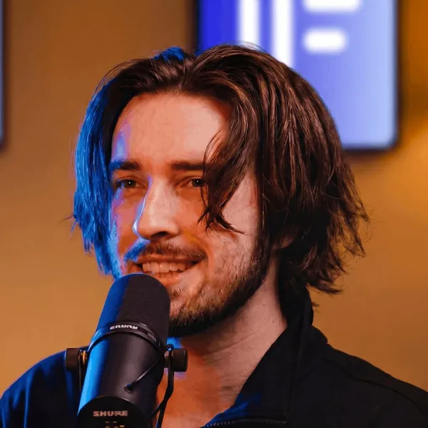 Porträt von Valentin Thomy, Gründer von Offbound, lächelnd hinter einem Podcast-Mikrofon
