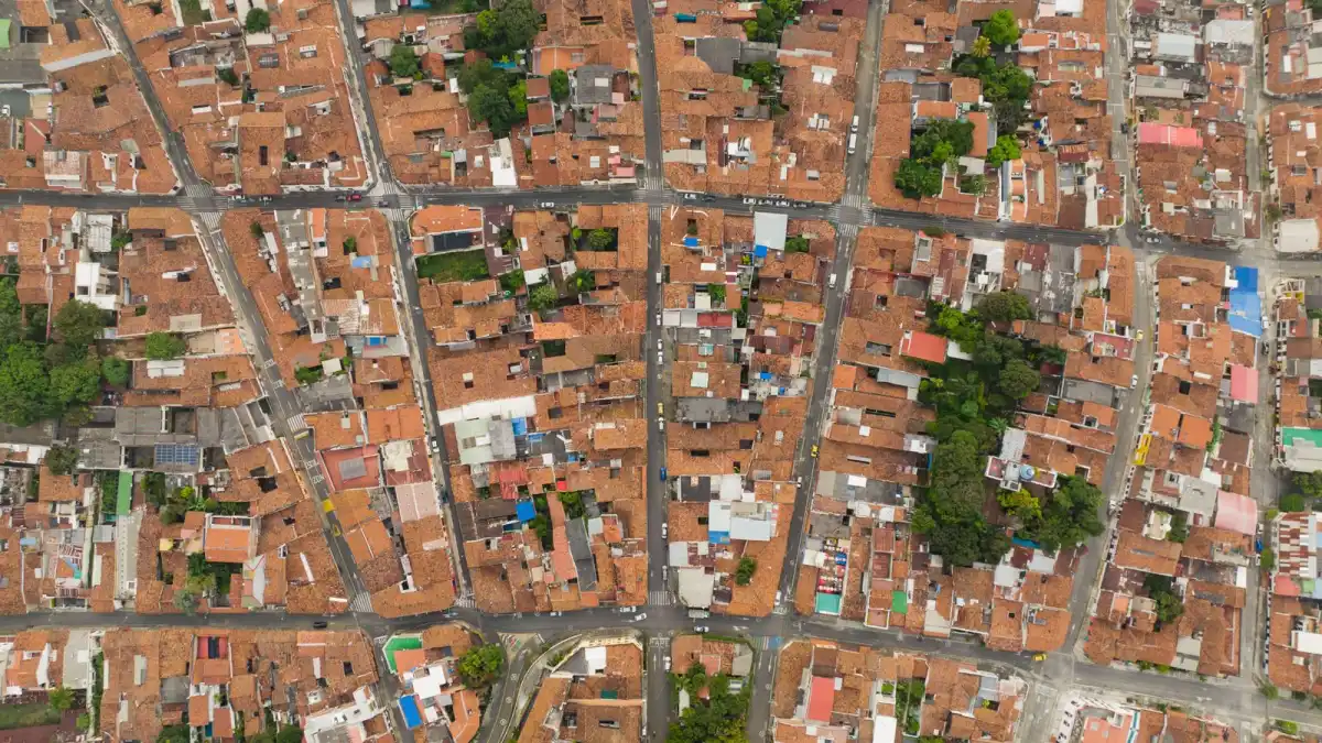 Aerial view of a dense neighbourhood with red roofs and tree-lined streets