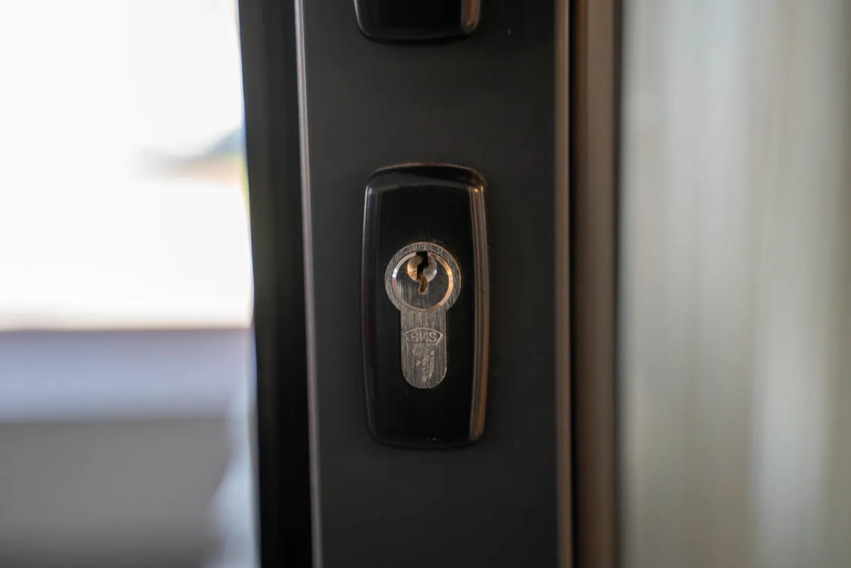 Close-up of a steel keyhole in a dark door frame
