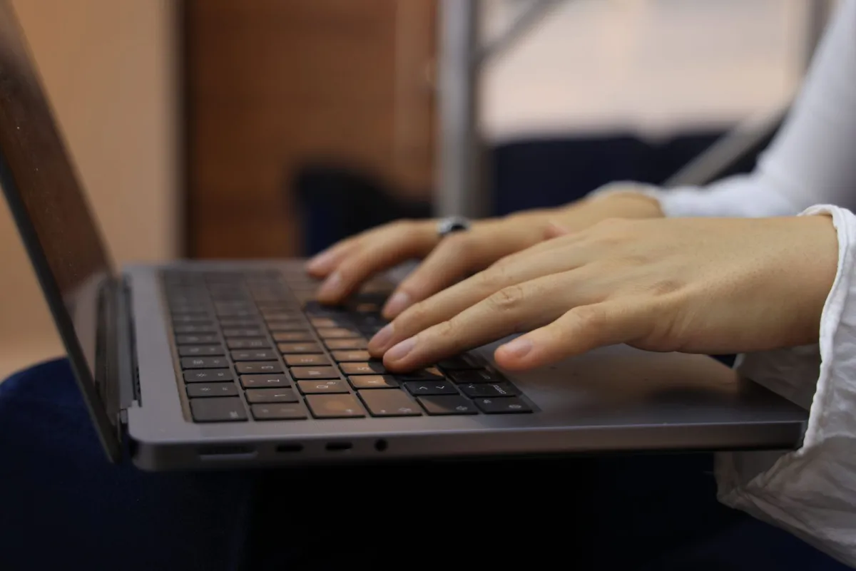 Handen die een paginatitel typen op een laptoptoetsenbord