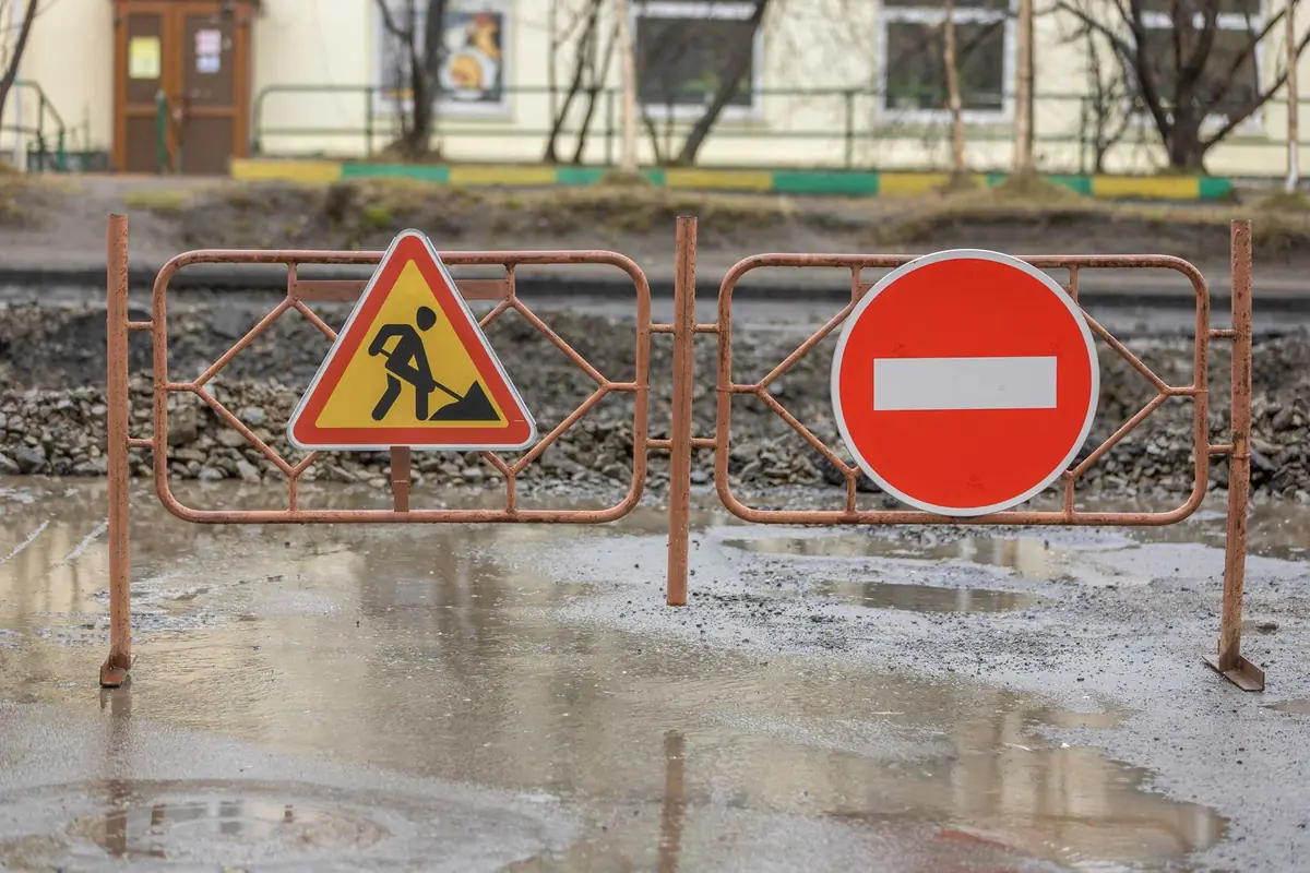 Çamurlu bir şantiyede girilmez işareti ve yol çalışması bariyeri