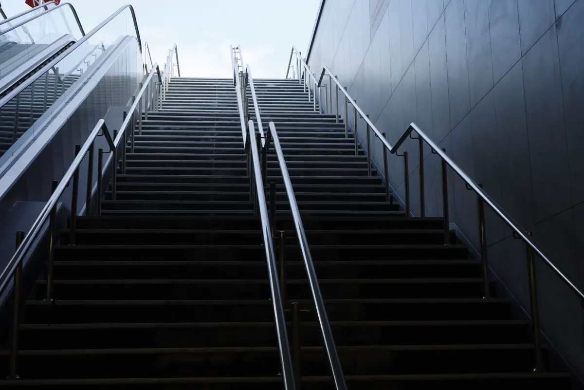 Long staircase rising toward the sky between two walls