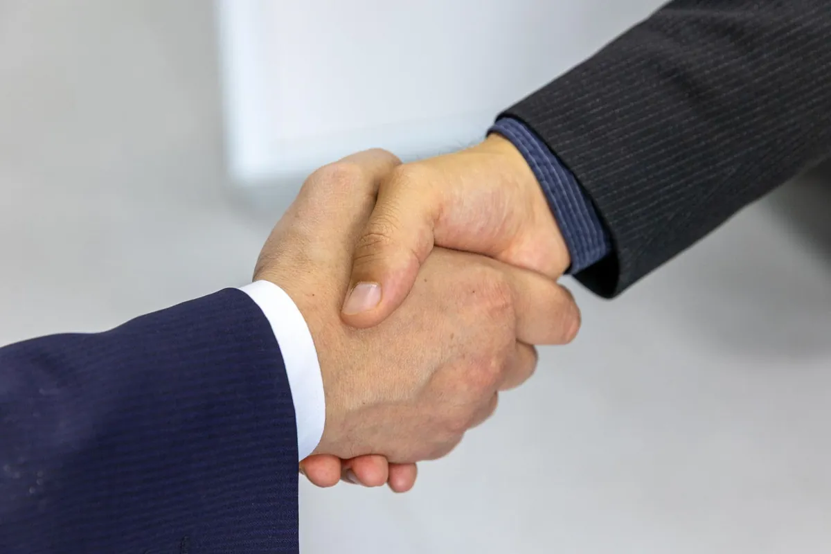 Two businessmen shaking hands to close a partnership