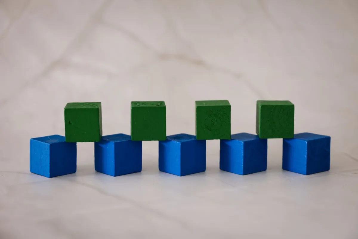 Blue and green wooden blocks arranged in a neat, regular pattern on marble