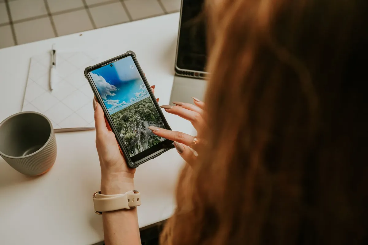 Woman scrolling on her smartphone at an office desk