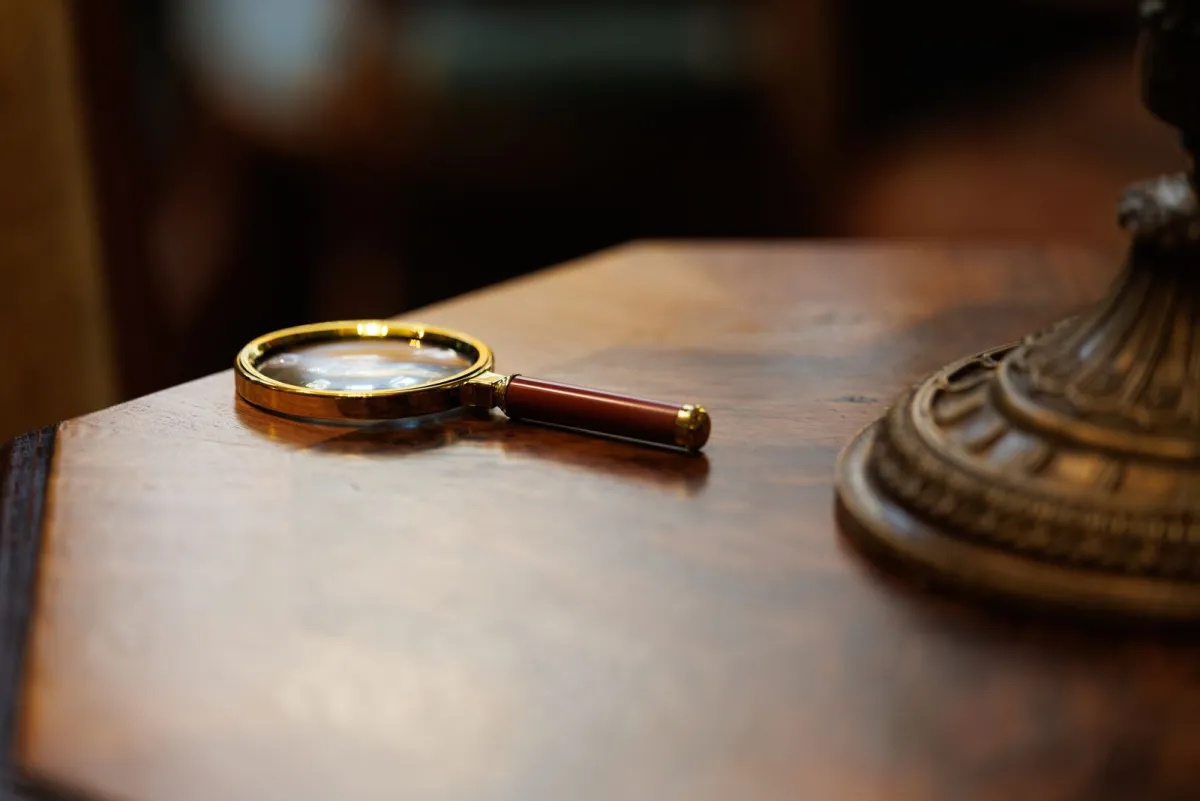 Magnifying glass lying on a polished wooden desk