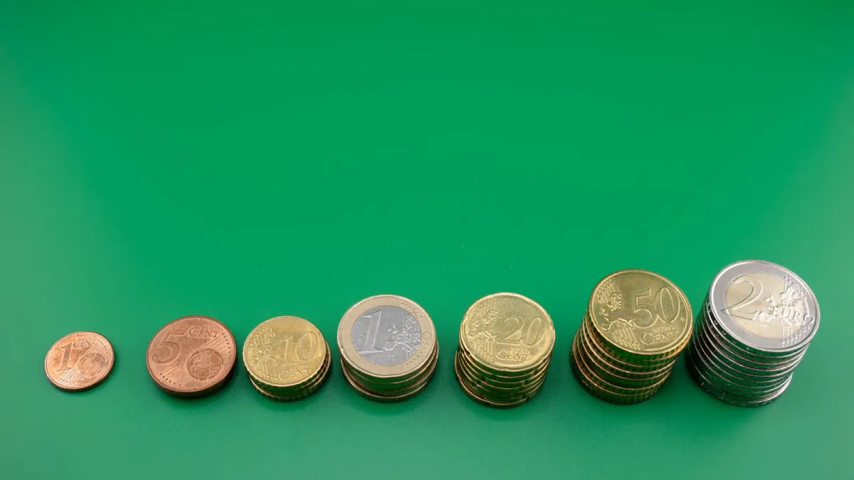 Coins arranged in stacks of increasing height on a green background