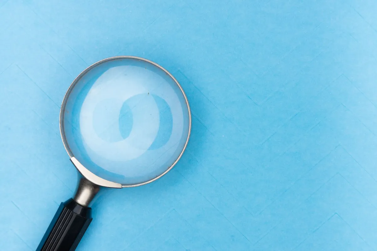 Magnifying glass lying on a light blue surface
