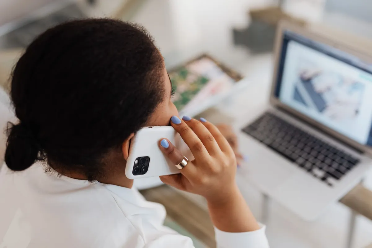 Woman on a phone call in front of her laptop