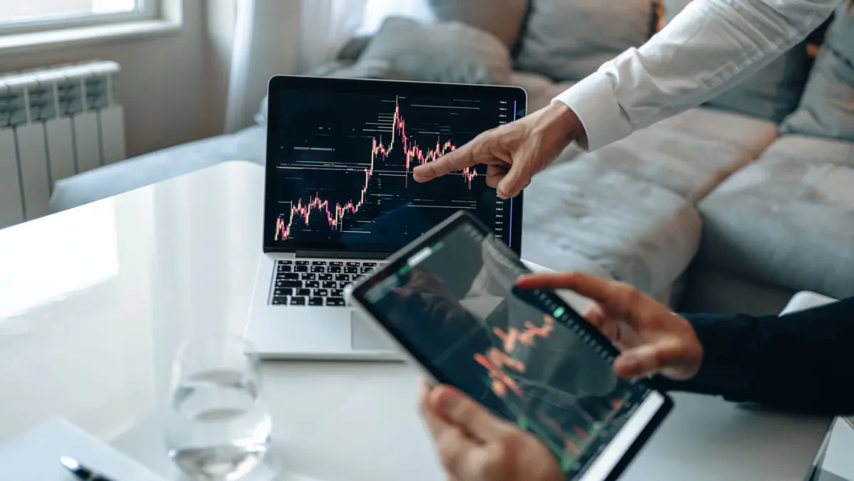 Two people reviewing growth charts on a laptop and a tablet