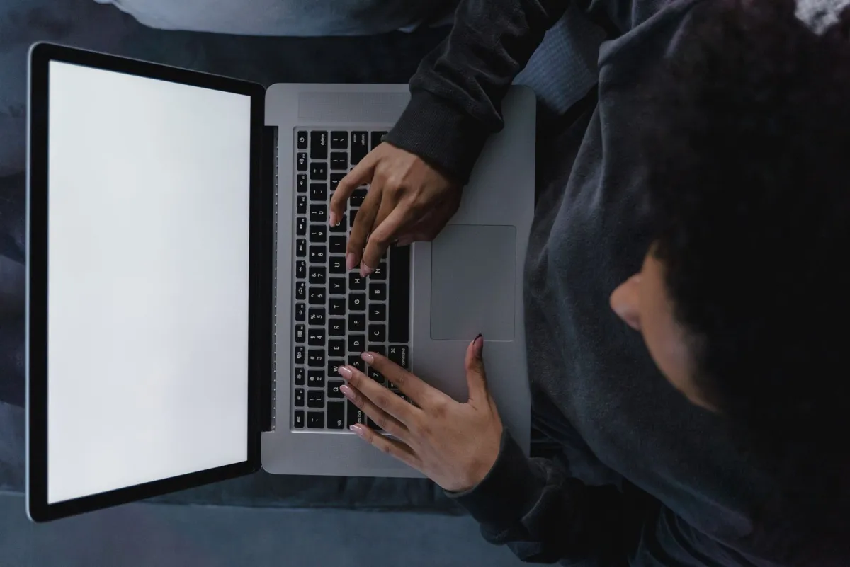 Persoon die typt op een laptop, van bovenaf gezien