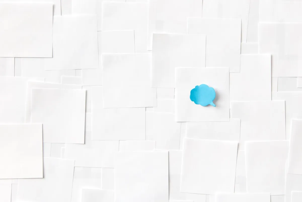 Blue paper speech bubble lying on a white surface