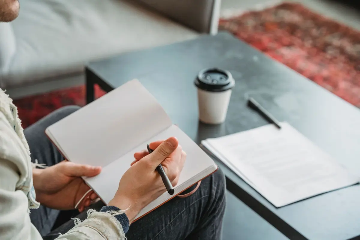 Schrijver die in een notitieboek meerdere ideeën voor koppen uitwerkt voordat hij er een kiest