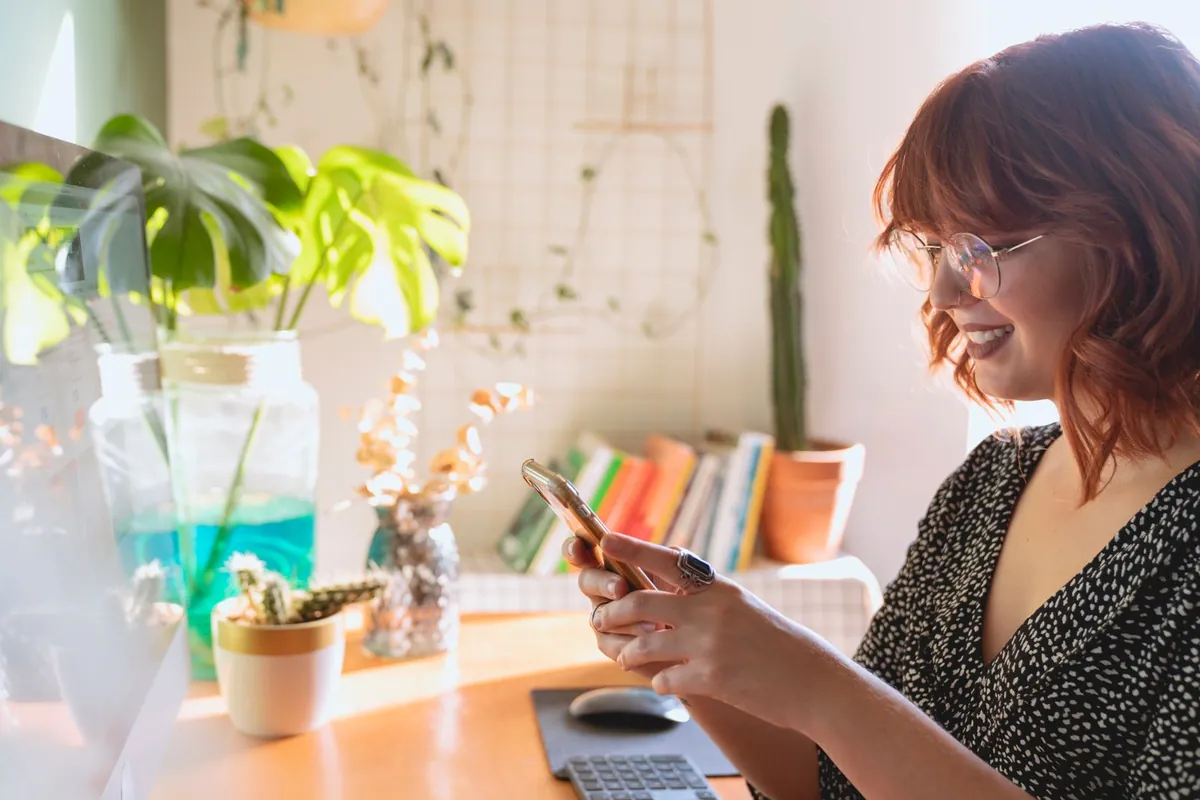 Woman in glasses reading on a tablet in a café, illustrating the ranking of the best email marketing software in 2027