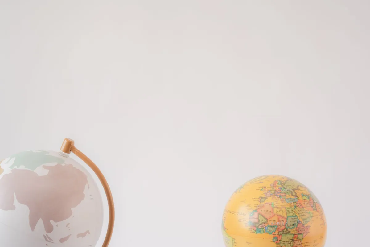 Two small globes on a plain light background