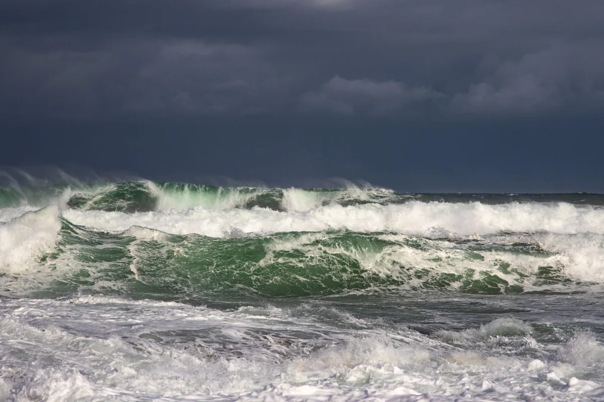 Powerful waves breaking on a rough sea under dark storm clouds
