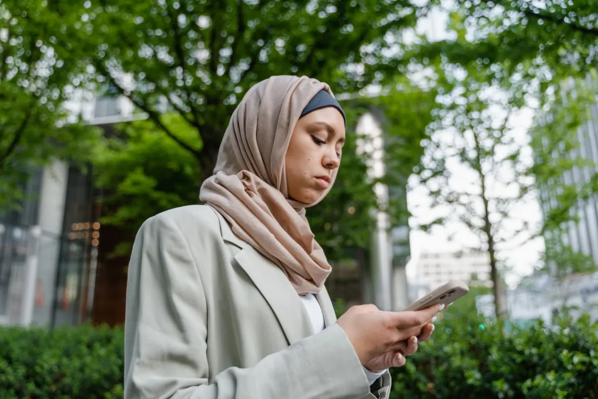 Woman reading an answer on her smartphone in a city park