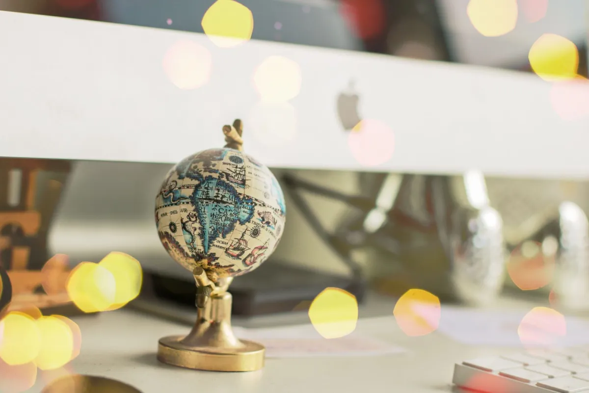 Miniature globe on an office desk with soft lights behind it