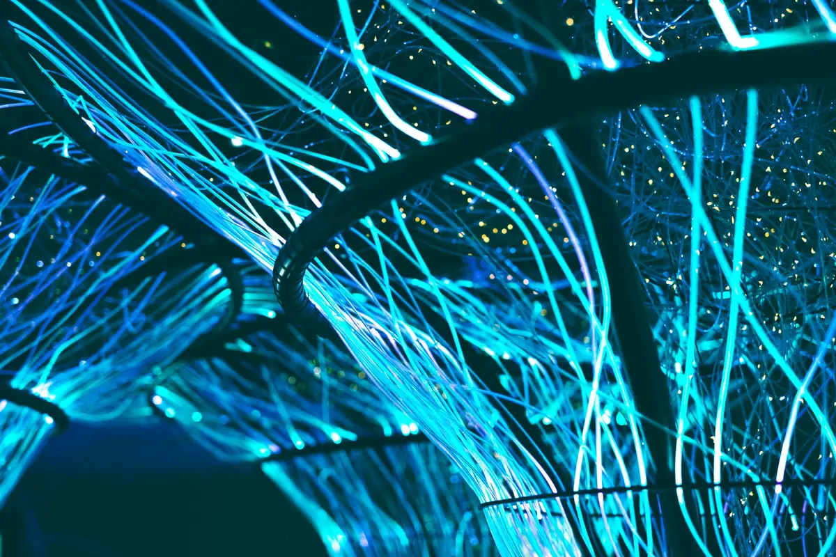 Glowing blue optical fibers forming a dense network of light