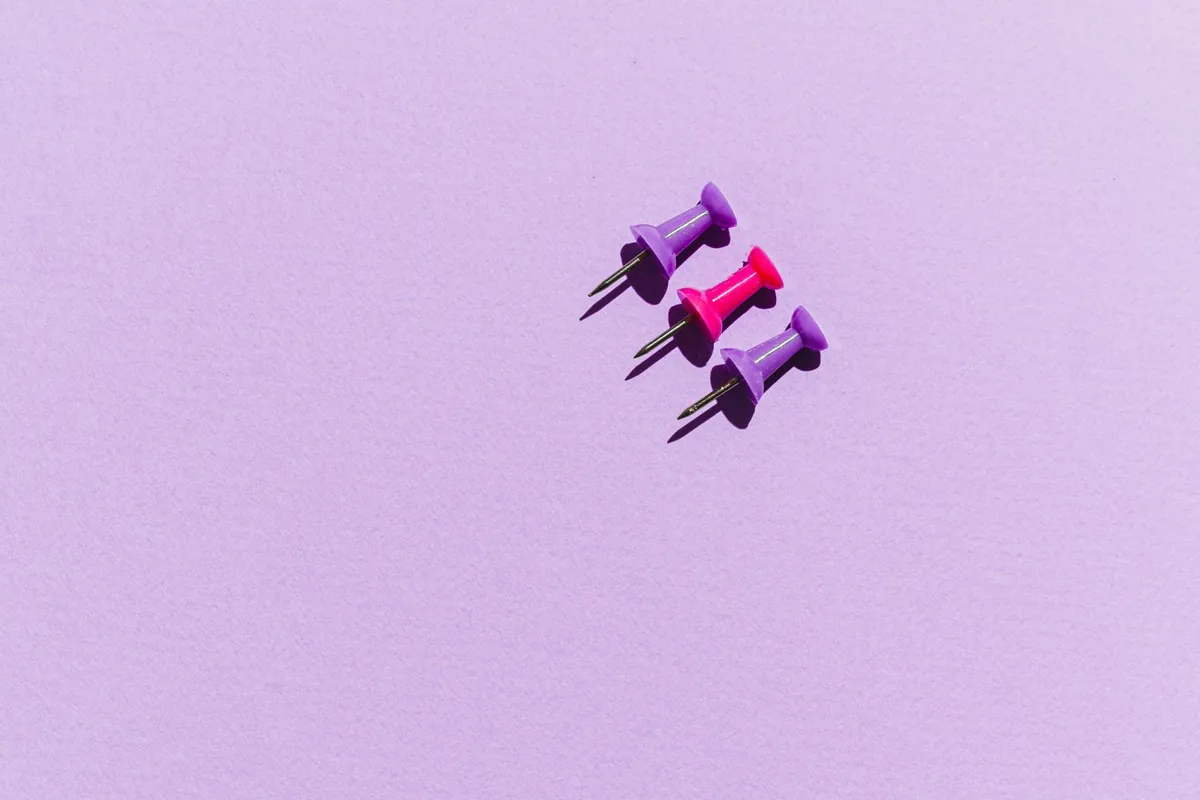 Drie punaises in paars en roze op een lila achtergrond