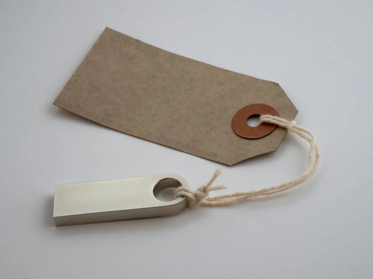 Blank kraft paper price tag tied with string on a grey background